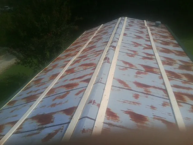 Rusted metal roof panels with new wood purlins before replacement — Storm Damage Roof Repair in Valley Springs by Roofing Brothers
