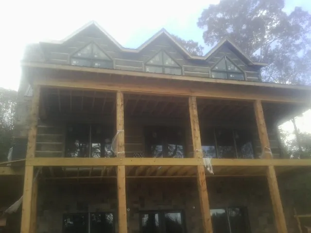 Dormers and porch framing on a large log home under construction — Roof Coating work by our crew in Valley Springs