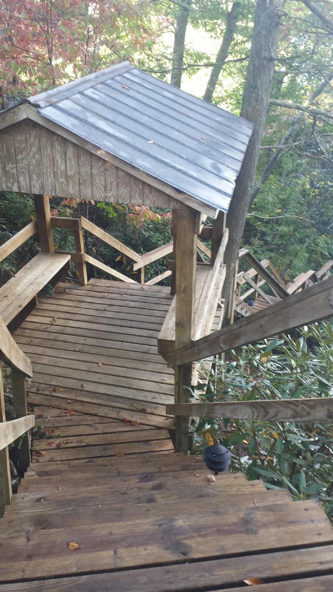 Metal roofed shelter over wooden steps on a wooded walkway — Skylight Repair & Installation work by our crew in Valley Springs